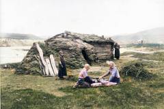 Skoltesamiske barn spiller et slags damspill utenfor gammen, 1905. St. Georgs kapell i bakgrunnen. I forgrunnen et fehus. (Foto: Ellisif Wessel)